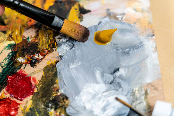 Кисть и палитра с цветными маслами от художника дома расслабились