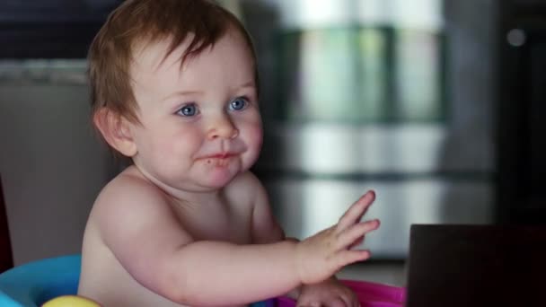 Cute baby waves and smiles while eating dinner — Stock Video