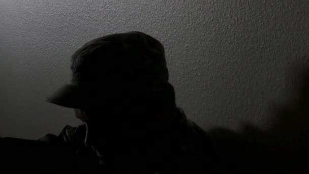 Ένας στρατιώτης σιλουέτα στηρίζεται ενάντια σε έναν τοίχο του χωλ, φράζω, 4Κ — Αρχείο Βίντεο