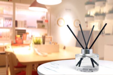Lüks aroma aromalı sazlık dağıtıcı kristal şişe oda spreyi ve dekorasyon malzemeleri olarak oturma odasındaki beyaz mermer masa üzerinde güzel masa ve sandalye arka planı ile ortam rahatlatmak için kullanılır.
