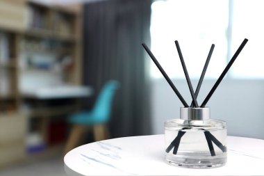 Asgari tasarım dekorasyon odasındaki beyaz mermer masada sabahları rahatlamak ve romantik ortam yaratmak için oda spreyi olarak kullanılıyor. 