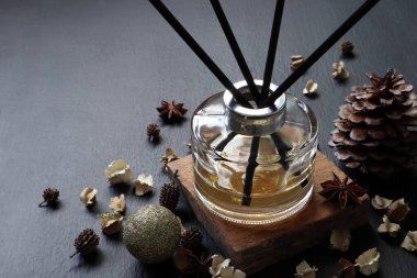 Noel 'de otelin lobisindeki yeni yıl kutlaması sırasında kurutulmuş çiçekler ve süslemelerle süslenmiş ahşap masanın üzerinde lüks kokulu sazlık cam şişe bulunuyor.