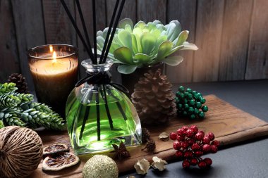 aromatik kokulu sazlıklar veya oda spreyi çeşitli otlar, baharatlar ve kurutulmuş potpuri ile dekore edilmiş ahşap masa üzerinde Noel partisi boyunca evin oturma odasında bulunur. 