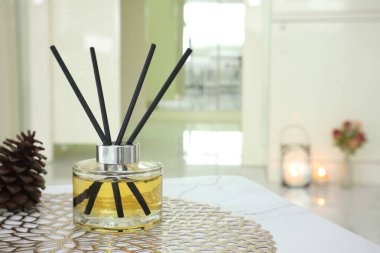  Sazlık cam şişesinin lüks aromatik kokusu yatak odasında kokulu mum ve sabahları pencereden gelen ışığın arka planıyla mermer masada oda spreyi olarak kullanılır.