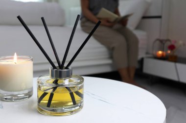 Lüks aroma aromalı difüzyon şişesi beyaz mermer sehpanın üzerinde, kokulu cam kokulu romantik yaratmak ve sevgililer gününde beyaz yatak odasındaki ortamı yumuşatmak için.