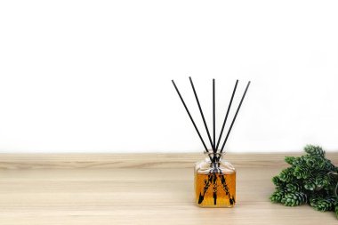 Lüks kokulu kamış aromalı difüzyon şişesi ahşap masanın üzerinde romantik yaratmak ve yatak odasındaki ortamı yumuşatmak için sabah beyaz çimento duvarlı arka planda Sevgililer Günü için.