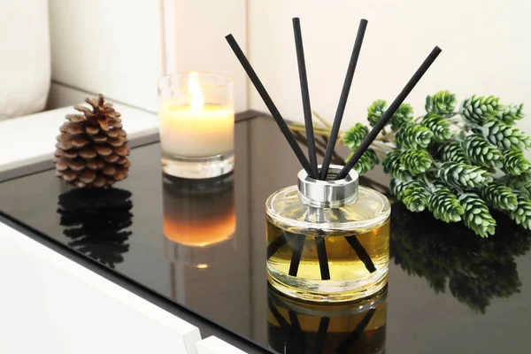 : luxury aromatic scent reed diffuser glass bottle and scented cand are used as room freshener on bedside table in the bedroom with background of the white bed in the morning of valentine day