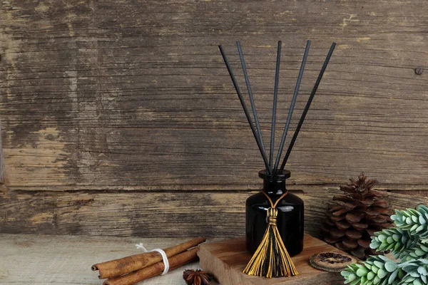 stock image nice aromatic scented reed diffuser air freshener bottle on wooden table with pine cone and background of old vintage wooden texture wall of living room to creat realx ambient in cottage for christmas