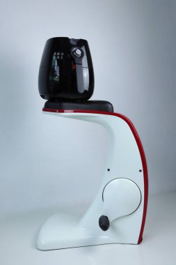 Siyah hava fritözü spor salonunun beyaz çimento duvar arka planına sahip bisiklet makinesinde, 