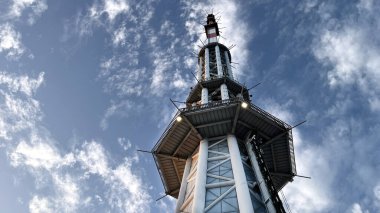 upper part of Canton Tower in Guangzhou, China, captured from a low-angle view against a clear blue sky, showcasing its modern steel structure and architectural details famous tourists attractive