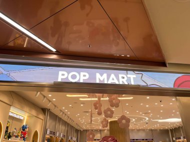 led sign of Pop Mart logo , popular collectable cute toy blind box mystery box from China with cute skull panda character on shop sign at the street in luxury mall during set up before opening