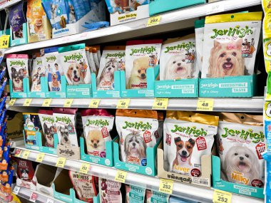 Renkli köpek maması paketleri ya da süpermarket raflarında düzgünce dizilmiş köpek mamaları, satışı destekleyen evcil hayvan ürünleri perakendecisi koridorunda parlak ambalajlarda çeşitli köpek maması gösteriliyor.