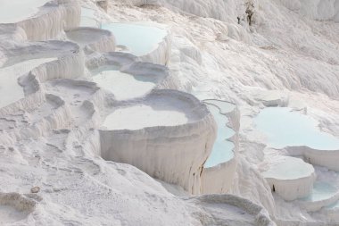 Türkiye 'nin Pamukkale kentindeki beyaz dağ beldesinde mavi suyla teras bulutu şeklinde güzel kıvrımlar.