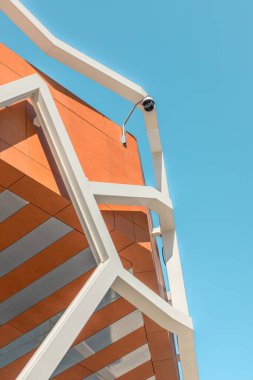 Mavi gökyüzüne karşı binanın çatısındaki kapalı devre kamerasında dikey çekim..