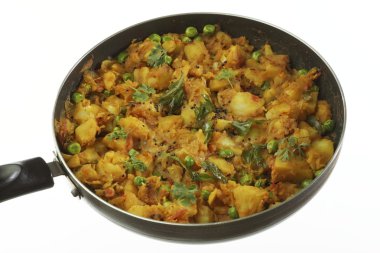 Baharatlı patates hazırlık diğer sebze soğan ve yeşil bezelye gibi ile pişirilir.