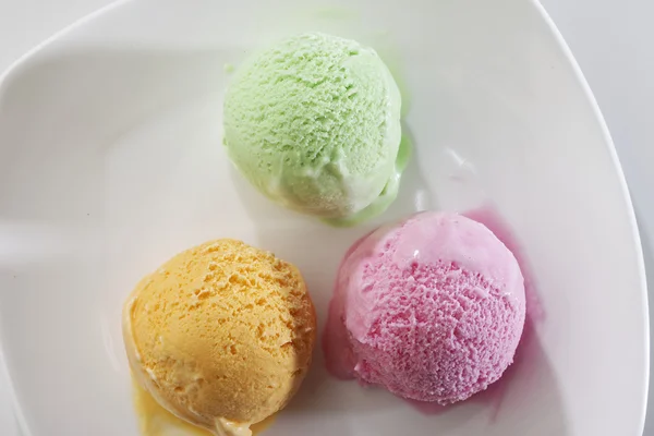 Una cucharada de delicioso helado fresco real en sabor a mango, fresa y pistacho . — Foto de Stock