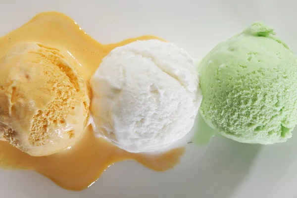 Cucharada de helado fresco real en sabor a vainilla, pistacho y mango . — Foto de Stock