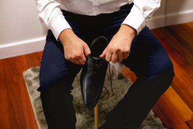 Siyah ayakkabı giyen, koyu mavi pantolon giyen, iş kıyafetlerini giyen bir adam.