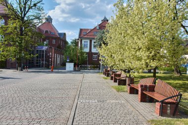 Eski Juliusz hastanesinin tarihi kırmızı tuğla binaları ahşap park bankları ve kaldırım taşı yolları, Rybnik, Slaskie, Polonya, Avrupa.