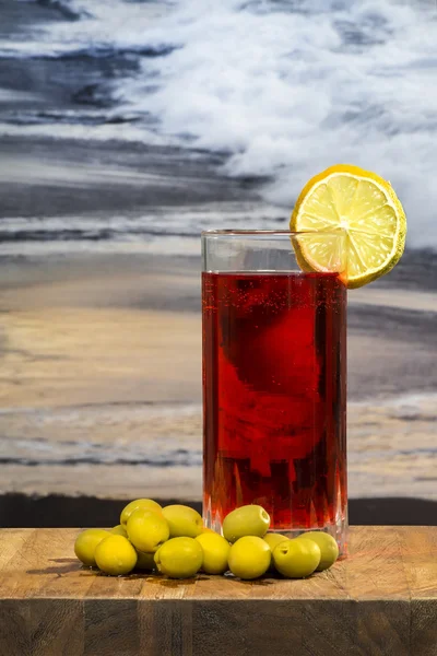 Vaso de vermut con aceitunas sobre una mesa de madera — Foto de Stock