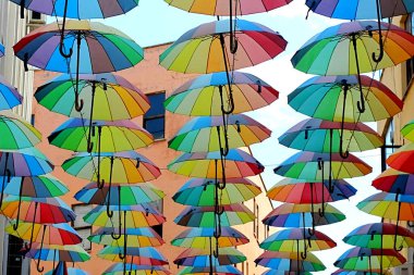 Caddenin üstünde bir sürü renkli şemsiye asılı.