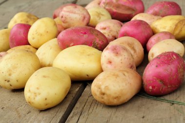 Tahta arka planda bir yığın taze patates, seçici fokus..