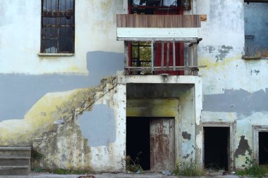 Pencereleri ve kapıları kırık, eski terk edilmiş bir ev..