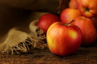 Büyük kırmızı-sarı elma koyu ahşap fokusun arka planında, yakın plan..