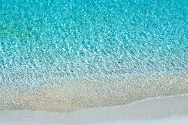 Turkuaz deniz dalgaları ve Akdeniz 'deki beyaz kumsal. Yukarıdan görüntüle.