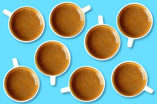 Set of the white cups of coffee on a blue background top view, minimal style.