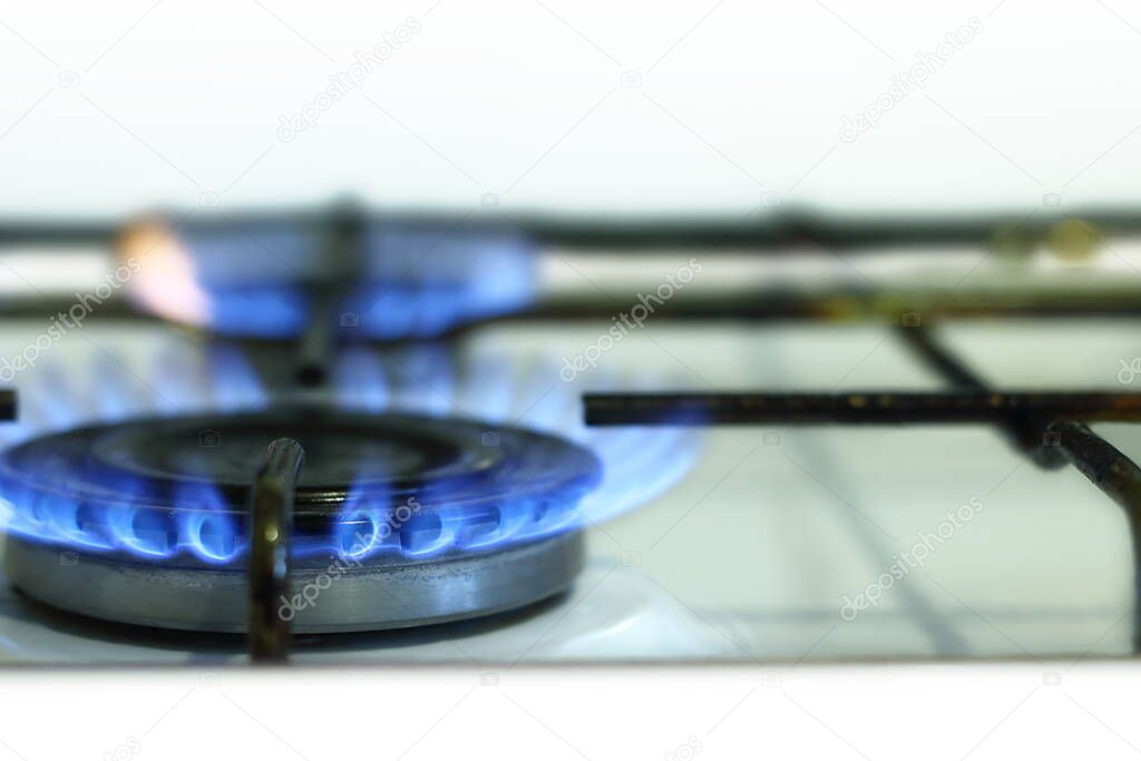 Kitchen gas stove with burning gas flame close up.