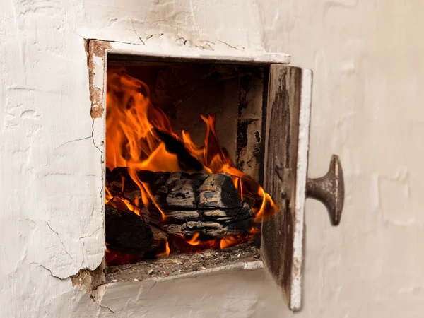 Offene weiße Tür, rustikale Öfen, brennendes Holz und Feuer — Stockfoto