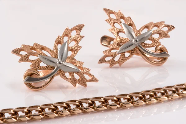 Χρυσή αλυσίδα και χρυσά σκουλαρίκια με τη μορφή του σφενδάμνου αφήνει embelli — Φωτογραφία Αρχείου