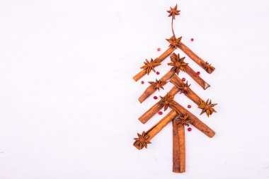 Tarçın, anason ve biber Beyaz ahşap zemin üzerinde bir köknar ağacı şeklinde