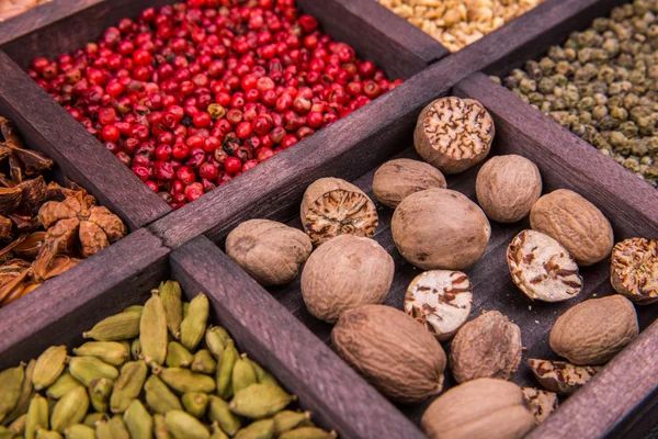 Nutmeg and spices in a wooden box — Stock Photo, Image