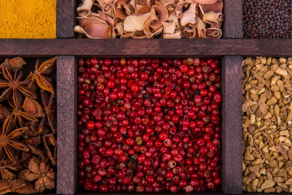 Piros paprika, a carnation és a fűszereket egy fadobozban — Stock Fotó