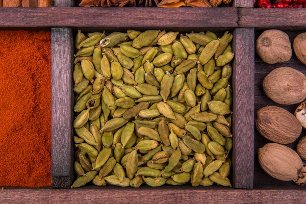 Cardamom, paprika and nutmeg in a wooden box — Stock Photo, Image