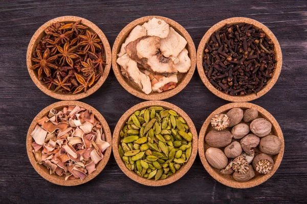 Spices in round forms on a dark wooden board