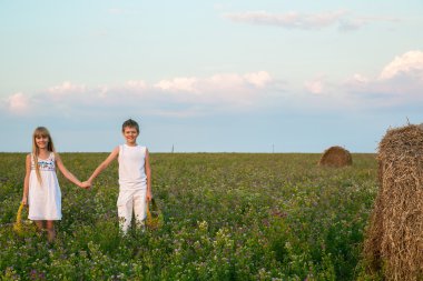 Oğlan ve kız bir glade ellerini tutun