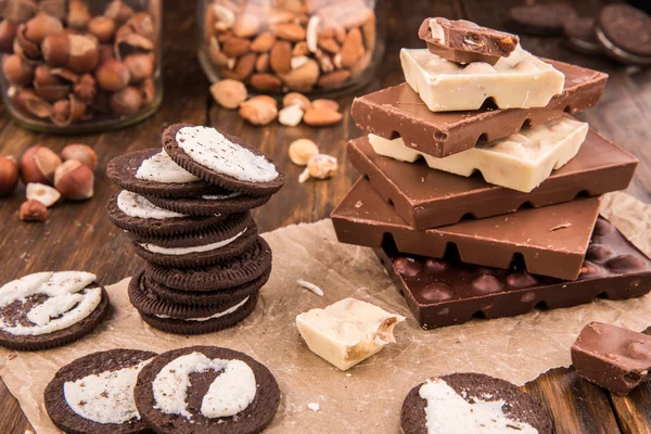 Шоколадное и шоколадное печенье с орехами на темной деревянной доске — стоковое фото