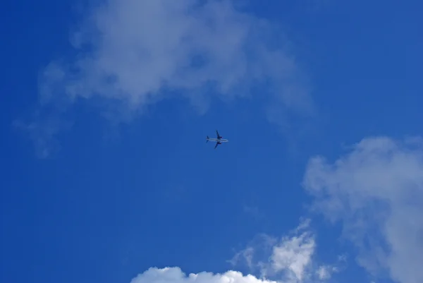Το αεροπλάνο στον ουρανό μεταξύ άσπρα σύννεφα — Φωτογραφία Αρχείου