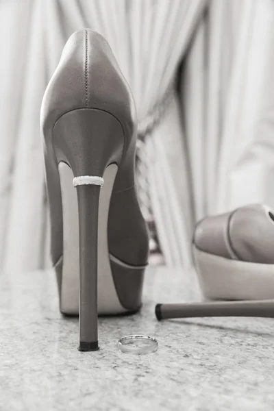 Los zapatos de la novia con el anillo de boda en el tacón — Foto de Stock