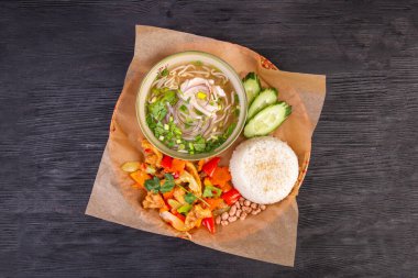 Haşlanmış sebzeler, haşlanmış et, pirinç ve taze salatalık ile kapsamlı bir öğle yemeği.