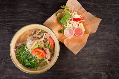 domatesli çorba, pirinç eriştesi, et parçaları ve doğranmış sebze