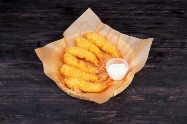 Ekmek kırıntıları içinde kızarmış karides, ekşi krema sosuyla servis edilir.