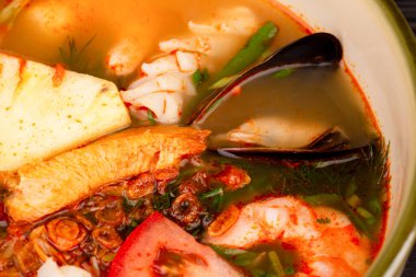 Domates çorbası Tom Yam ile midye, karides, ananas, balık ve yeşillik