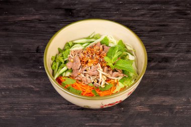 Et parçalı salata, taze sebze, salatalık, havuç, marul yaprağı ile servis edilir.