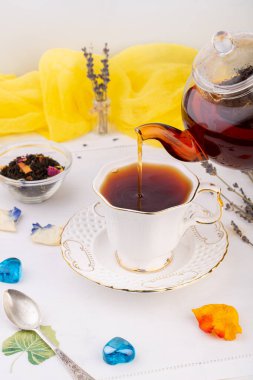 Çay seremonisi, çaydanlıkta siyah çay, masada duran beyaz fincana dökülür.