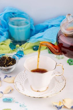 Çay seremonisi, siyah kokulu çay, çaydanlıkta demlenmiş, beyaz fincana dökülmüş.