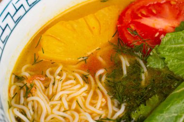 Pirinç erişteli çorba, domates, ananas ve doğranmış sebze.